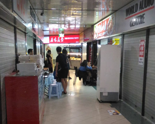 A small cluster of eateries among conspicuously inactive shops.